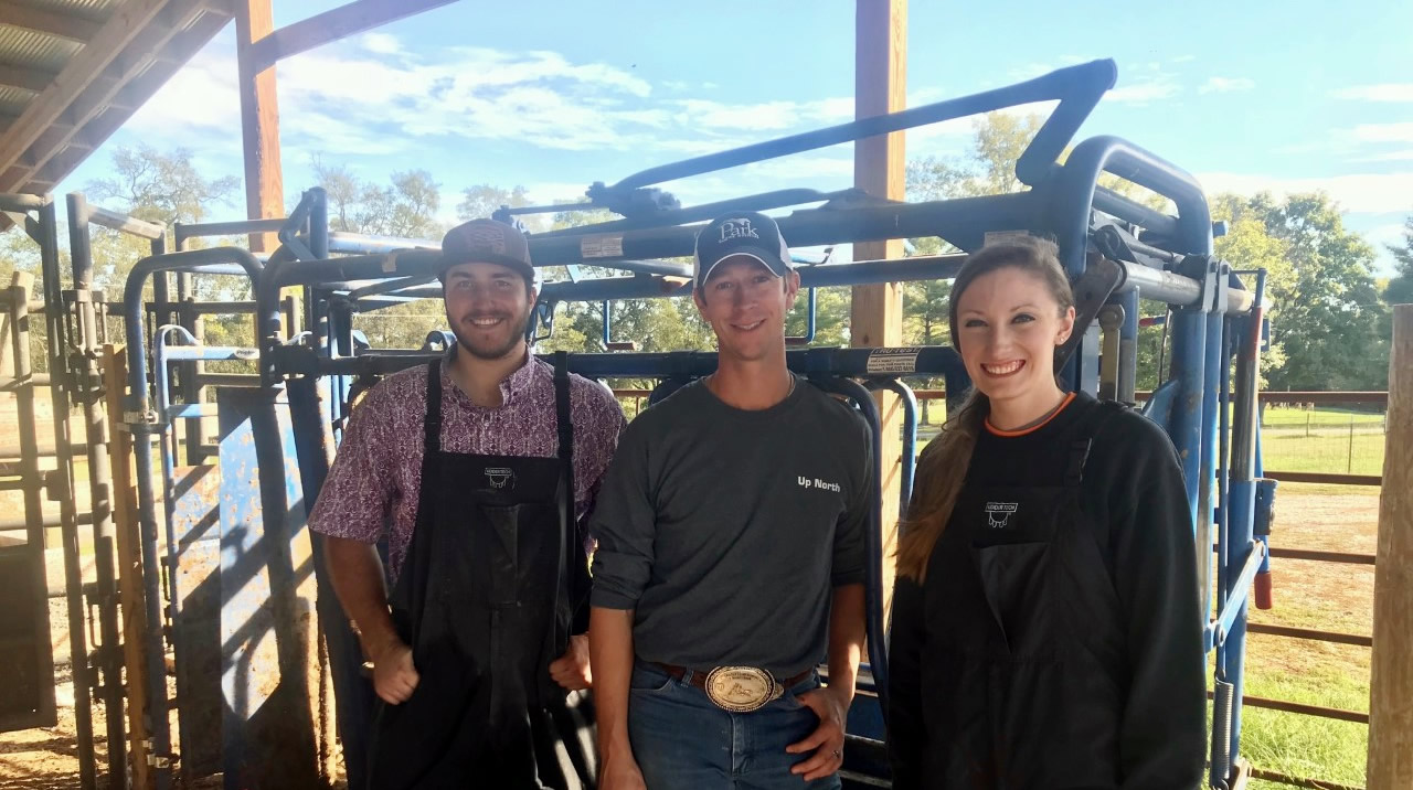 Kyle McLean with 2 grad students leaning against a chute