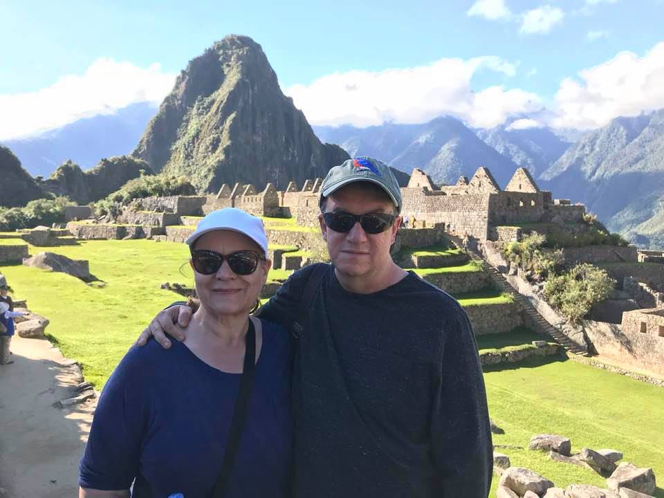 Barbara Gillespie and her husband standing in front of the Pisac ruins in Peru.