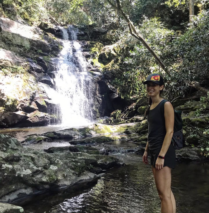 Elizabeth standing on a rock with a waterfall behind her