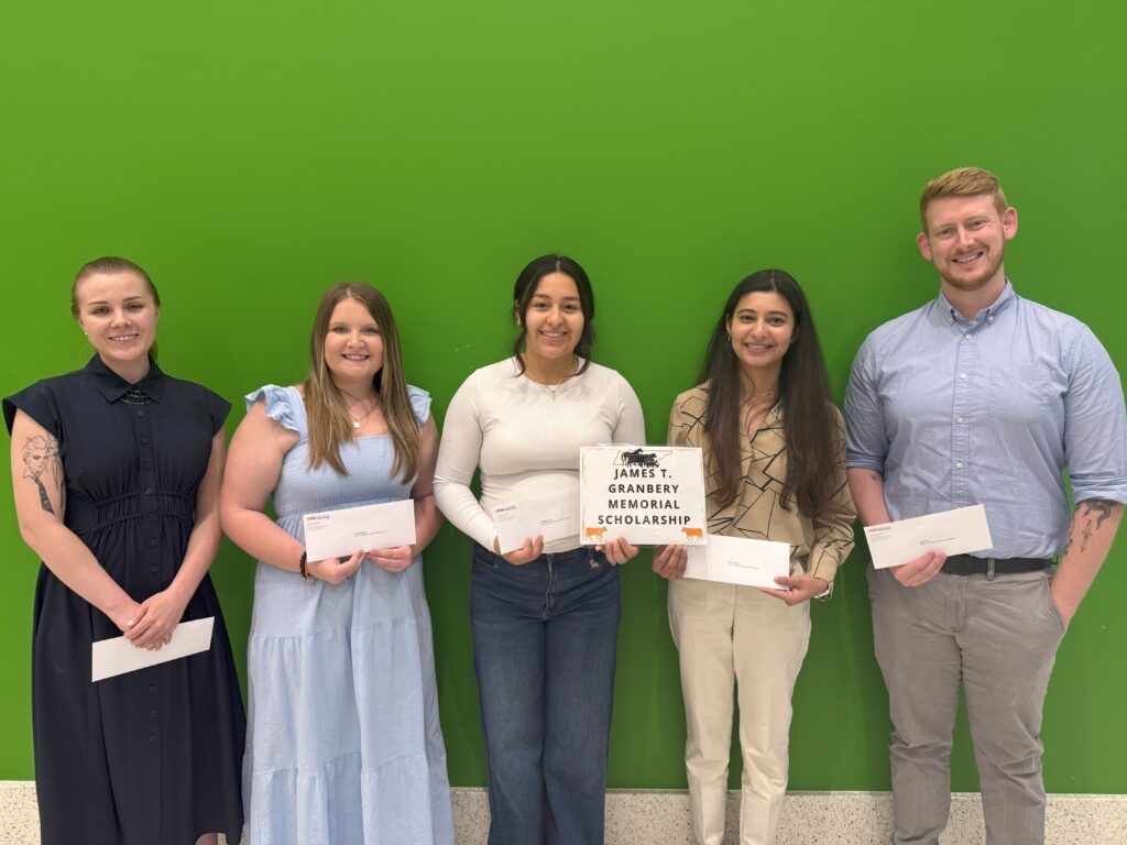 Group of students standing in front of a green wall
