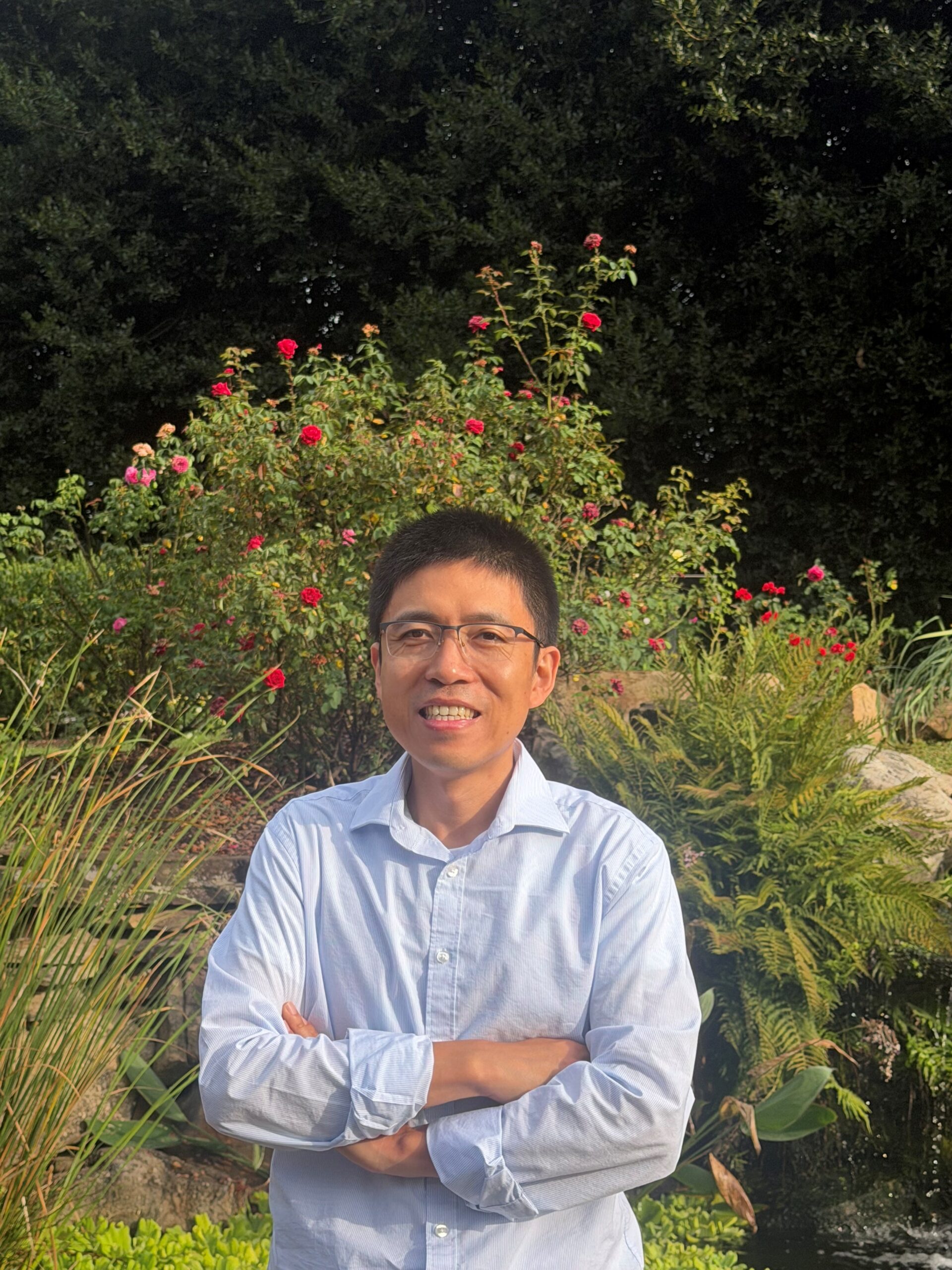 Dr. Li standing in UT Gardens 